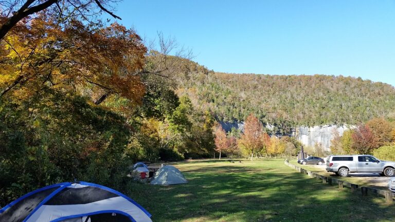 Scenic view of Steel Creek Campground at Buffalo National River, Arkansas, with towering limestone bluffs, lush green trees, and a peaceful river, perfect for camping, hiking, and outdoor adventure in the Ozarks.