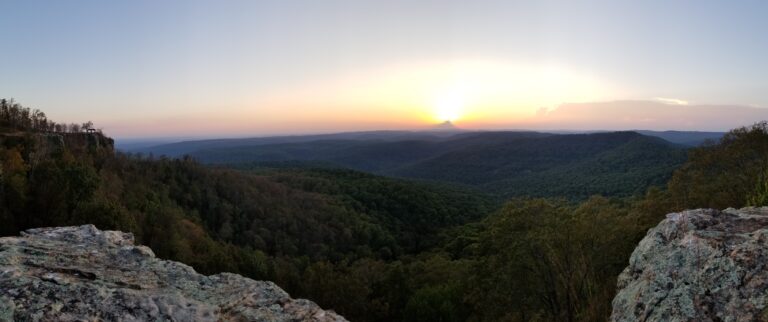 Panoramic sunset view from White Rock Mountain Rim Trail overlooking rolling green hills and expansive forested landscape in summer